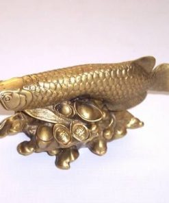 Pestele Arowana din metal inotand pe un strat de pepite